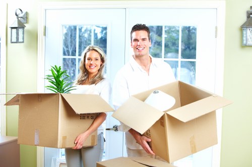 Moving team carrying boxes through a Clapham apartment building